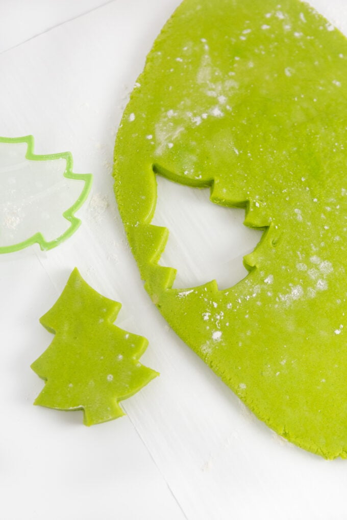 green sugar cookie dough with christmas tree shape cut out