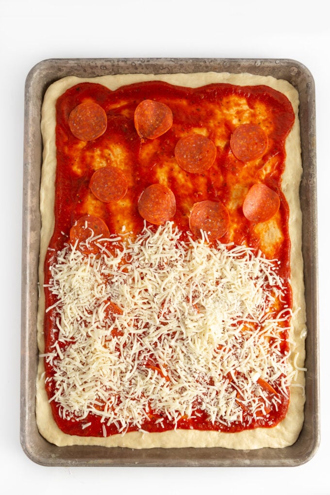 sheet tray of pizza with sauce, pepperoni, and cheese