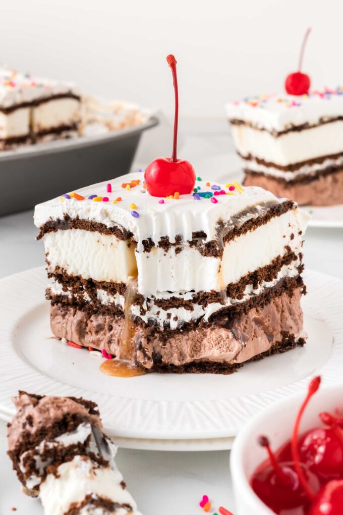 Square of ice cream sandwich cake on plate, with cherry on top