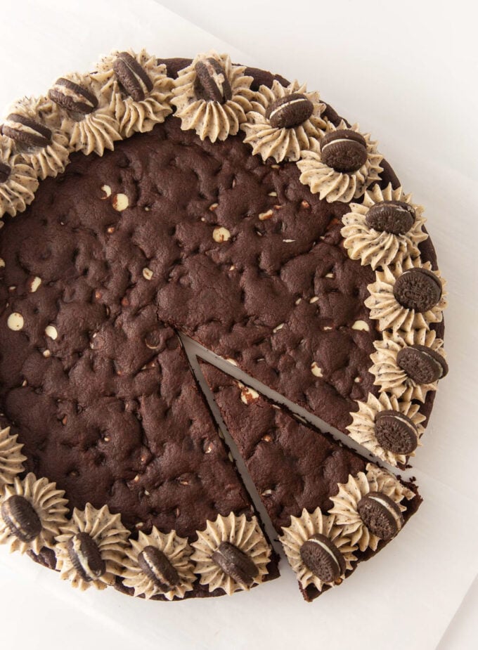 Overhead view of decorated Oreo pizza cookie cake with one slice cut
