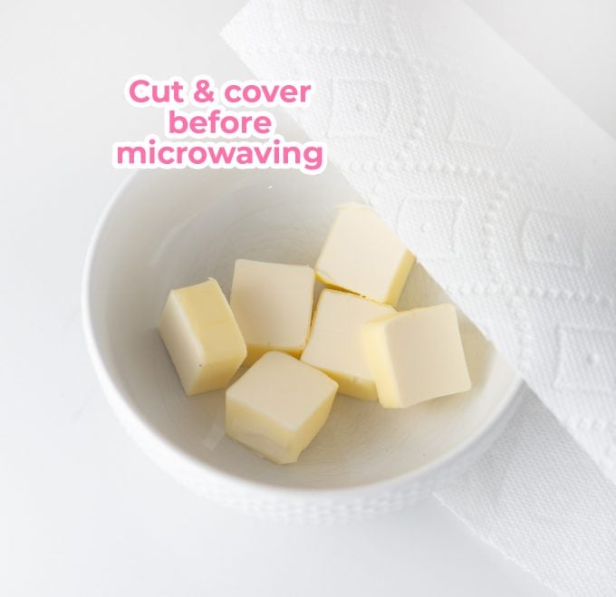 Bowl of butter cut into cubes and covered with paper towel for microwave