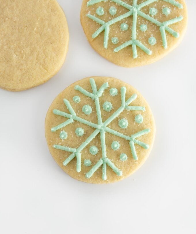 circle sugar cookie with blue snowflake piped on top