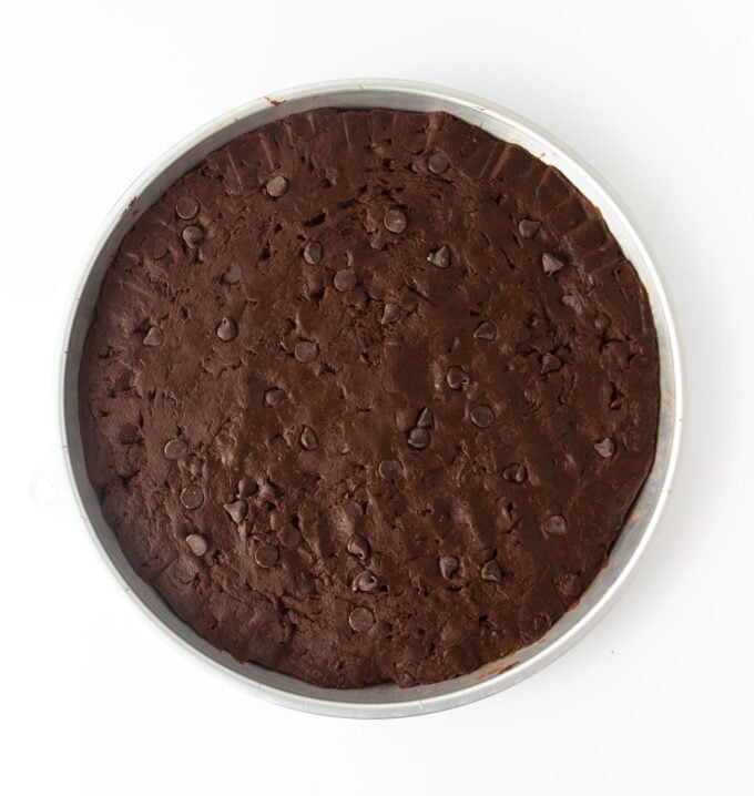 unbaked pan of triple chocolate cookie cake in round cookie cake pan